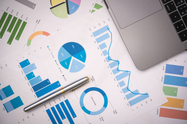 business documents on office table with smart phone and digital tablet and graph financial with social network diagram and computer laptop on wood desk