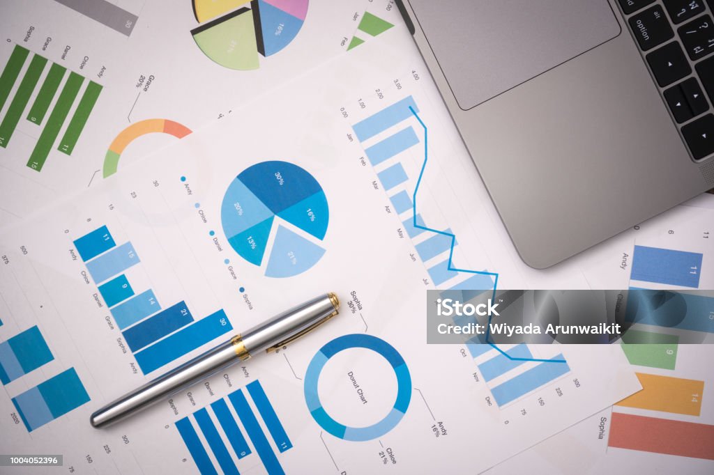 business documents on office table with smart phone and digital tablet and graph financial with social network diagram and computer laptop on wood desk Spreadsheet Stock Photo