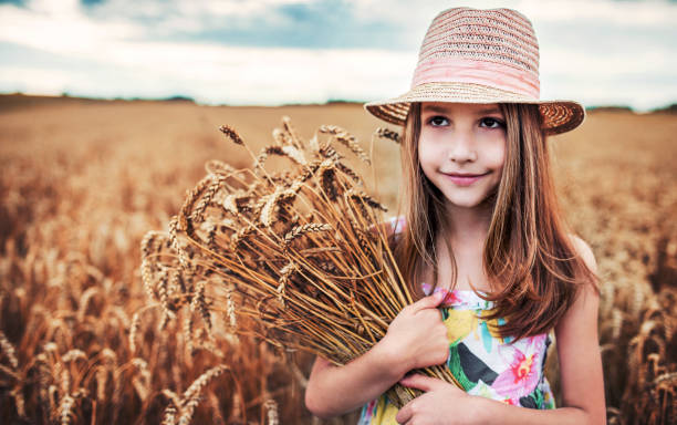 istock Girl with a hat in the wheat field 1004053402