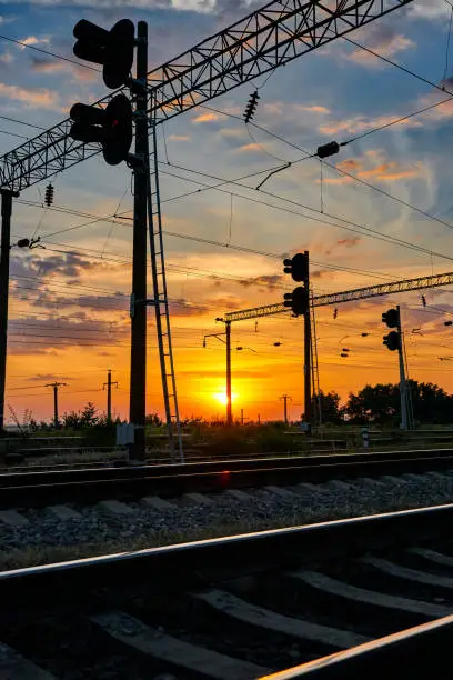 railroad infrastructure during beautiful sunset and colorful sky, railcar and traffic lights, transportation and industrial concept