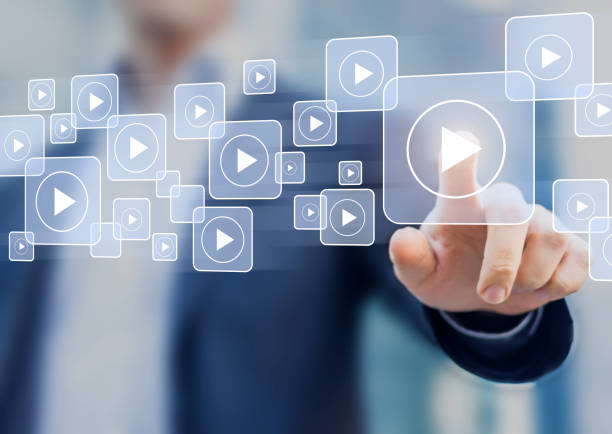 istock Video on demand technology with person touching play button on virtual screen to watch online VOD streaming of movie or TV 1004057462