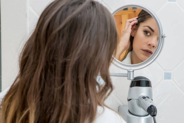 Woman in small mirror exploring soft skin