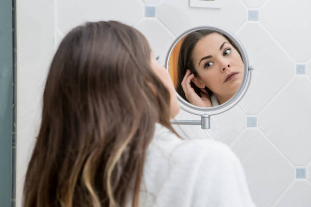 istock Beautiful woman looking at face in reflection 1004058002