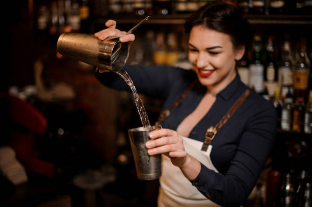 istock Beautiful sexy smiling barmaid making a fresh summer cocktail 1004070150