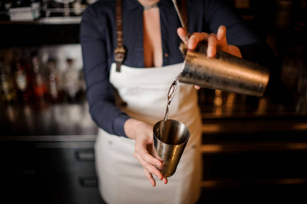 istock Sexy barmaid with a deep neckline making a fresh summer cocktail 1004073470