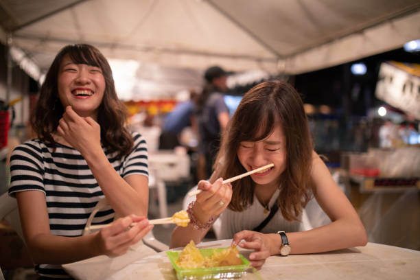 jóvenes amigas disfrutando en el festival de noche - market asia photography outdoors fotografías e imágenes de stock