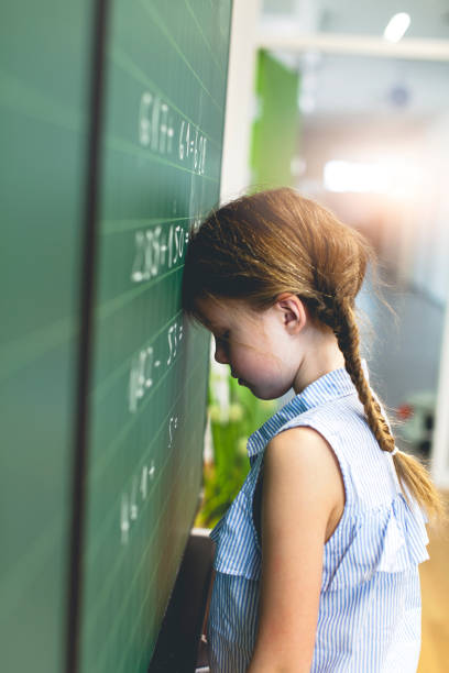 istock Side View Of Girl Leaning On Blackboard At Classroom 1004086244
