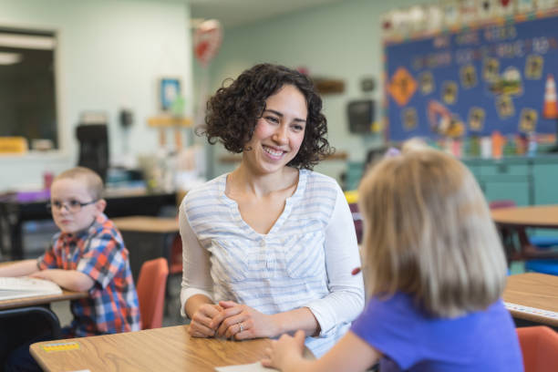 istock A first grade teacher talking with one of her students in the classroom 1004098316