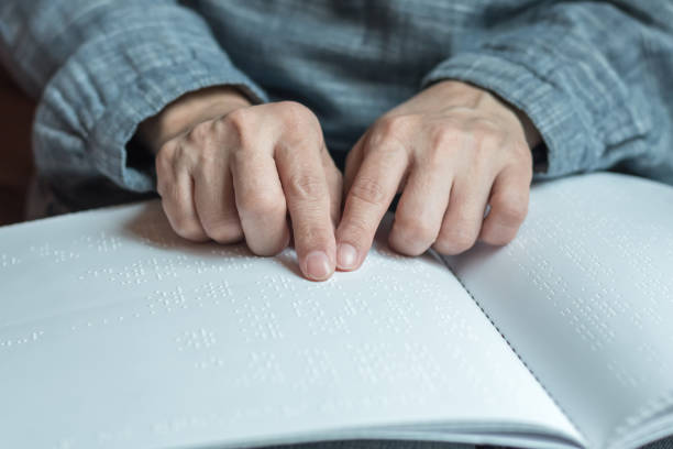 livro de braille para baixa visão / pessoa cega lendo braille sinal dedo tocando em relevo papel de textura para o dia mundial da visão e o conceito de consciência dia mundial de braille - eyesight senior adult care support - fotografias e filmes do acervo