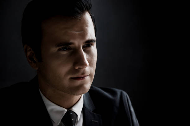 istock Man in shadow with serious face staring at interlocutor 1004108390