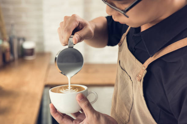 barista fa forma a rosetta latte art caffè - pouring coffee human hand cup foto e immagini stock
