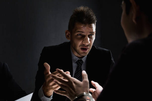 istock Criminal man being interviewed in interrogation room after committed a crime 1004108480