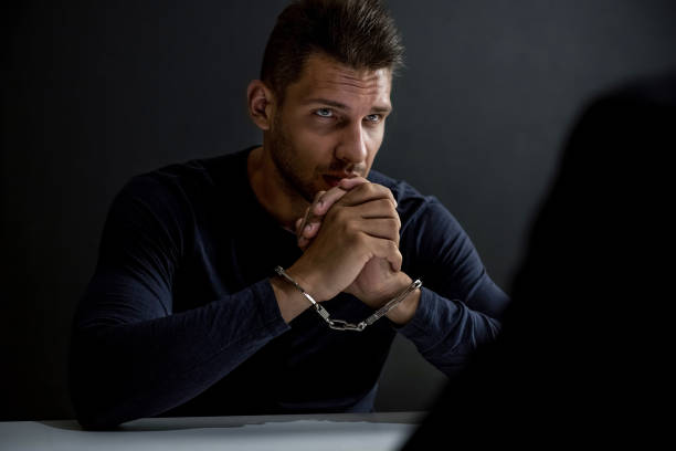 istock Suspect or criminal man with handcuffs  in interrogation room 1004108942