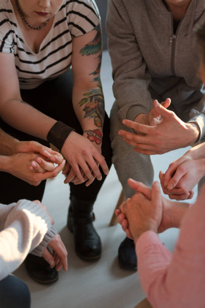 istock Young people with tattoos sitting in a circle during meeting of support group 1004109244