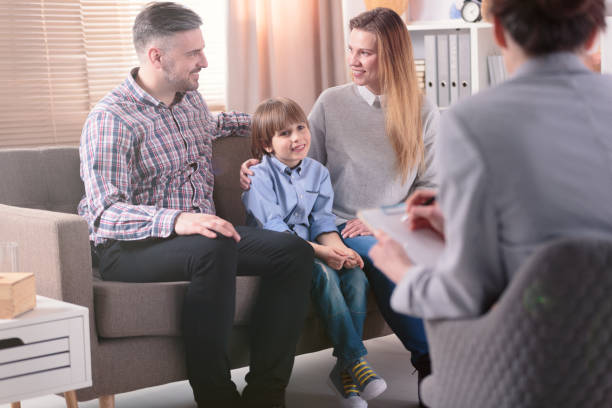 rückansicht auf erfolgreiche weibliche psychotherapeuten hilfe für junge familie mit einem kind probleme in der beziehung zu lösen. happy family im hintergrund - mental health professional family couple psychiatrist stock-fotos und bilder