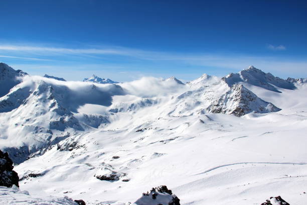 istock Snowy Mountains in the clouds blue sky Caucasus Elbrus 1004113916