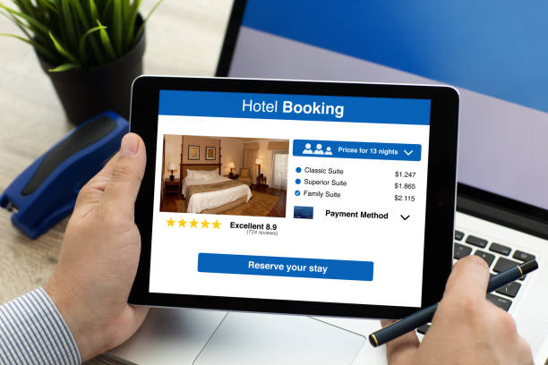 istock man holding tablet with app hotel booking on screen 1004121258