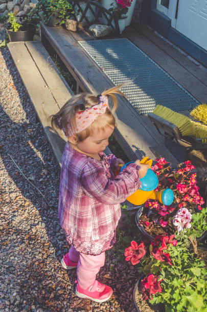 istock child with a watering can on a Sunny day 1004131586
