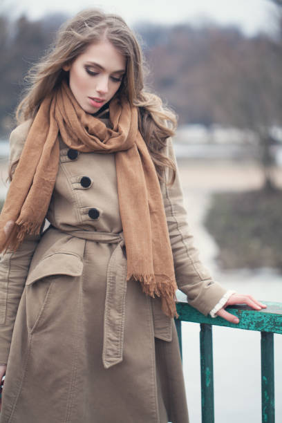 istock Stylish model wearing brown coat outdoors in park 1004131636