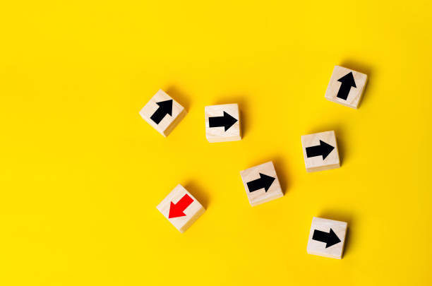 istock Wooden blocks with red arrow facing the opposite direction black arrows, Unique, dissenting opinion, individual and standing out from the crowd. divergent views 1004142256