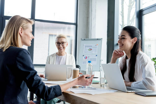 istock professional businesswomen smiling each other while working together in office 1004161102