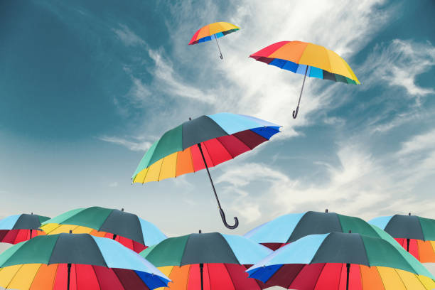 istock Rainbow umbrella fly out the mass of umbrellas 1004161292