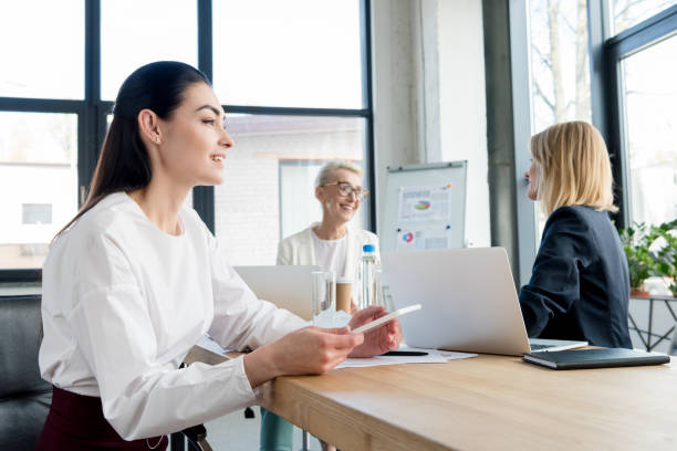 istock smiling professional businesswomen working with digital devices in office 1004161820