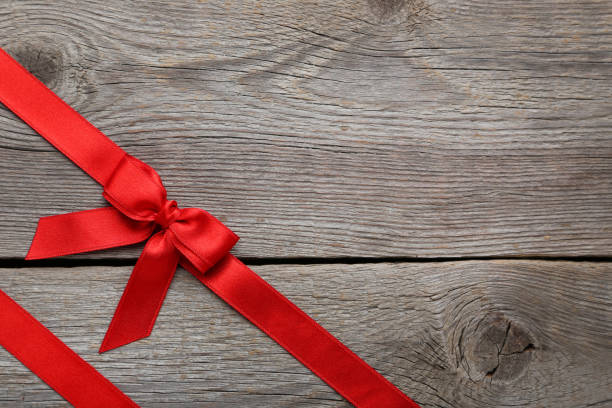 istock Red bow with ribbon on grey wooden table 1004165284