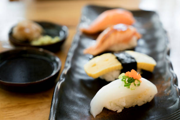 assorted varieties of sushi platter. raw fish sushi. japanese food. salmon burn, salmon, ika and tamago sushi in japanese food restaurant. - main course salmon meal course imagens e fotografias de stock