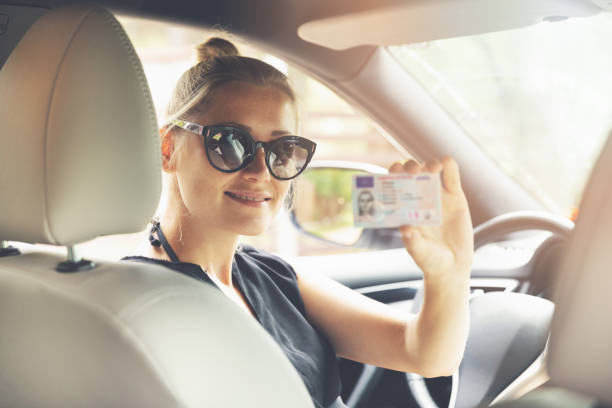 istock woman showing her new driver license in a car 1004169472