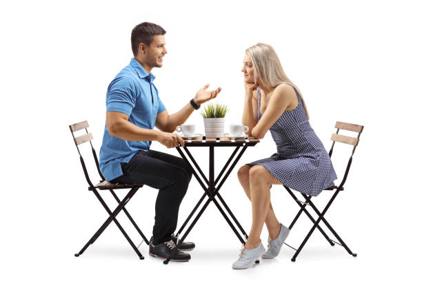 istock Young man and a young woman sitting at a coffee table and talking 1004172278