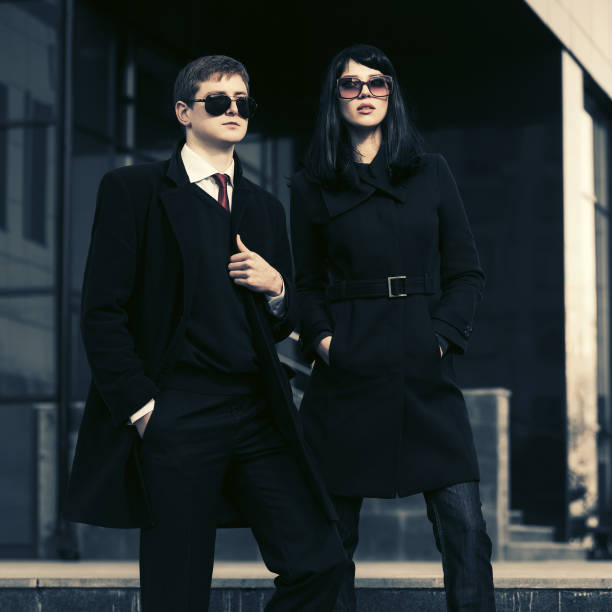 Young fashion business couple against office building stock photo