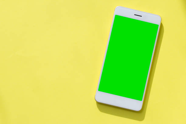 istock Smartphone with blank green display on yellow background 1004186536