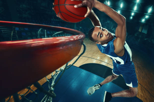 The african man basketball player jumping with ball The african man basketball player jumping with ball on black background basketball sport stock pictures, royalty-free photos & images