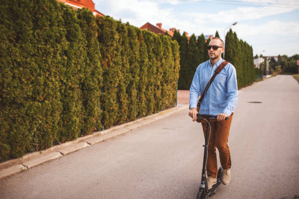 istock Young man riding on push scooter in city 1004191192