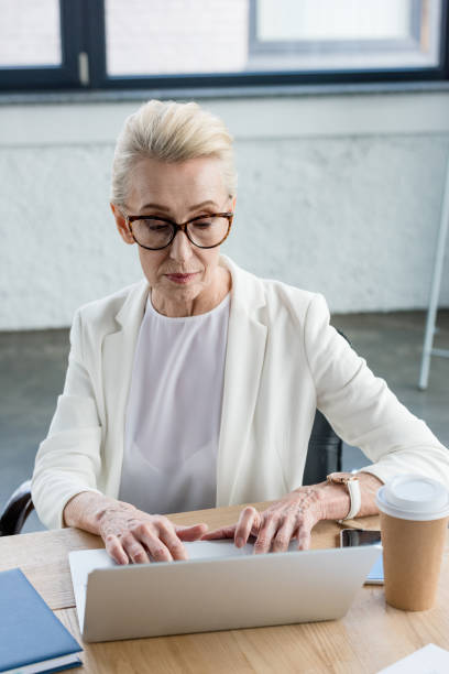 istock focused businesswoman in eyeglasses using laptop at workplace 1004191526