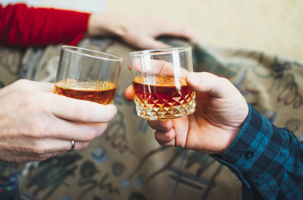 istock Hands with glasses of whiskey, clink 1004194914