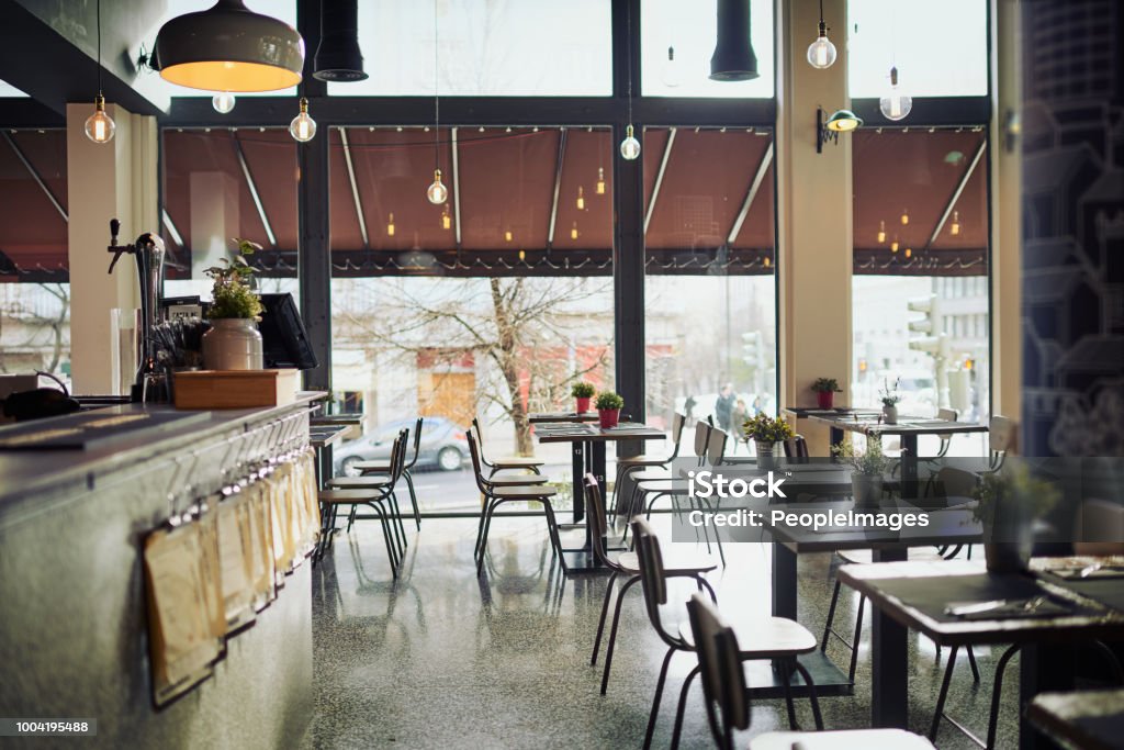 Come join us for a lunch Shot of an empty restaurant filled with tables and chairs inside during the day Restaurant Stock Photo