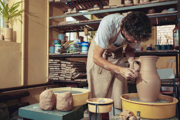 istock Creating a jar or vase of white clay close-up. Master crock 1004198604