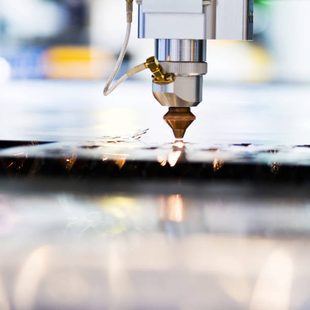 istock Laser cutting metal sheet with sparks flying 1004199306