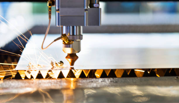 istock Laser cutting metal sheet with sparks flying 1004199308