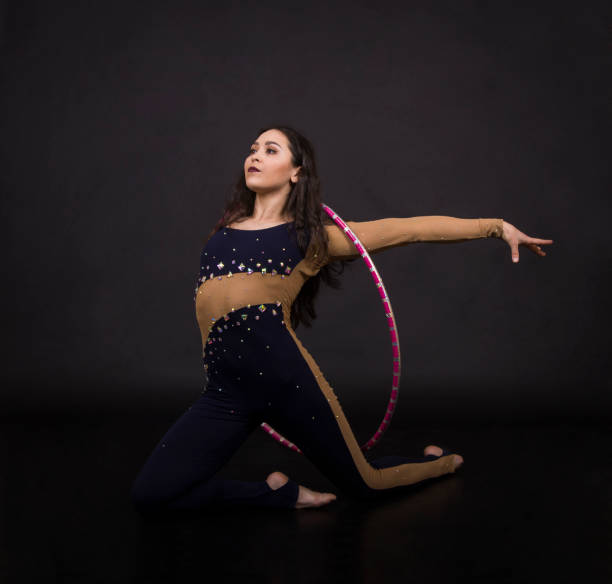 istock Gymnastic exercises with hula-Hoop girl performs circus performer in an artistic costume. 1004201546