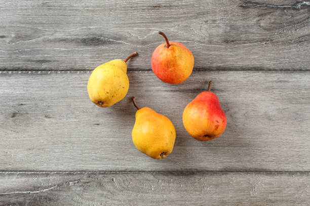 istock Table top view on four ripe pears on gray wood desk. 1004202374