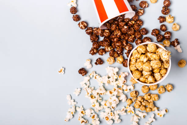 istock Assorted popcorn set in paper striped white red cup. Sweet and salty popcorn 1004202588