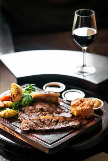 Photo of gourmet sunday roast beef traditional british meal set on old wooden pub table