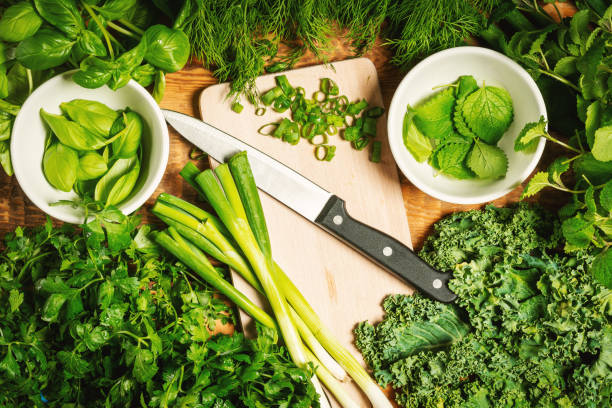istock green vegetables and spices on a wooden table with a knife 1004209970