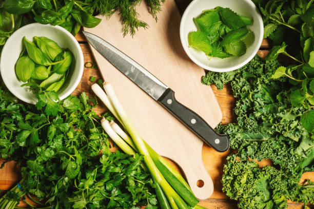 istock green vegetables and spices on a wooden table with a knife 1004209974