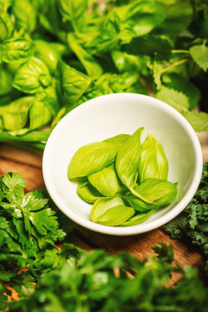 green vegetables and spices in bowls on a wooden table