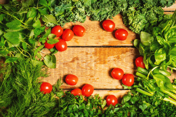 istock green vegetable herbs and tomatoes on a wooden table 1004212314