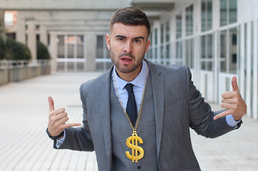 Businessman rocking golden necklace with dollar sign.
